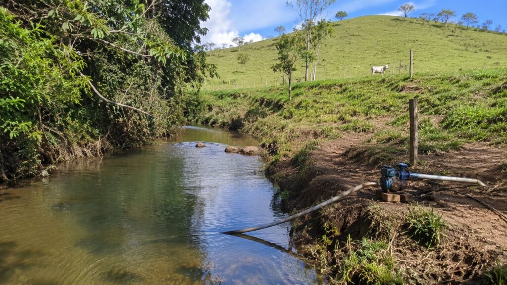 Bomba de água captando de um córrego para representar outorga e uso insignificante de água.